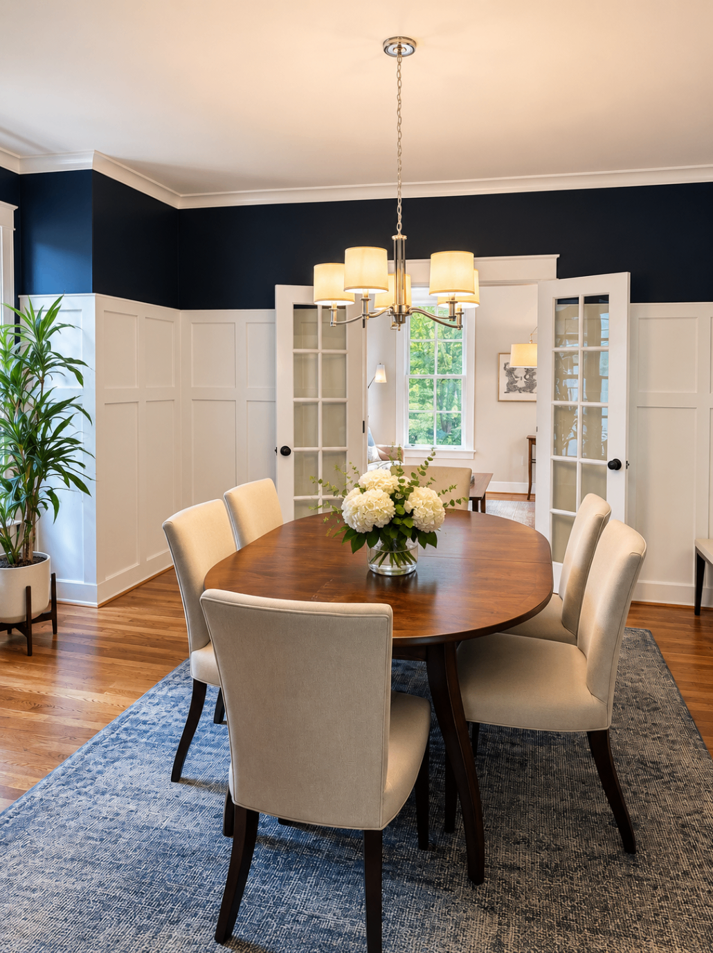 Formal dining room with navy walls and chandelier