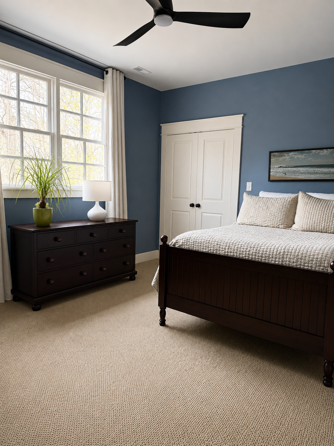 Mid-level bedroom with blue walls, king bed, and large window